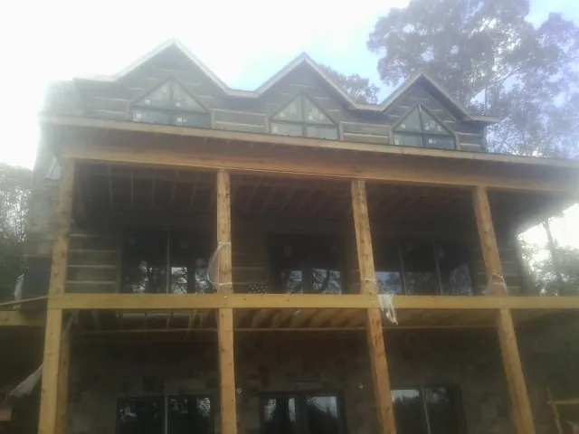 Dormers and porch framing on a large log home under construction — Roof Coating work by our crew in Bingen