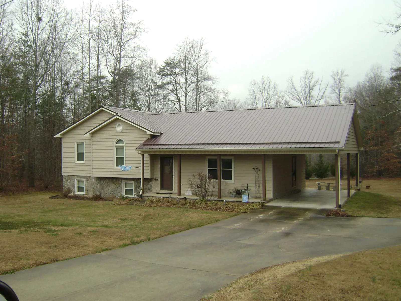 Brown metal roof on a tan split level home with an attached carport in Bingen